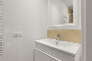 a white bathroom with a sink and a mirror at apt hospital in Tourrettes-sur-Loup +15 photos