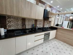 a kitchen with white cabinets and a sink at Villa skikda in Skikda +13 photos