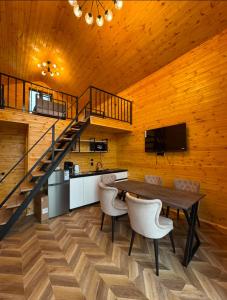a dining room with a table and a staircase at Барнхаус in Bosteri