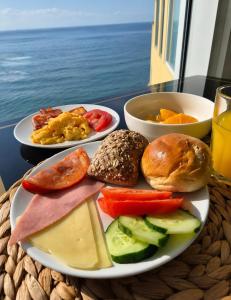 a plate with different types of food on a table at Vinha da Areia Beach Hotel in Vila Franca do Campo
