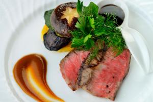 a plate of food with meat and vegetables and sauce at Amakusa Tenku No Fune in Kami Amakusa +40 photos