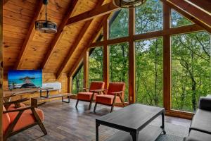 a living room in a log cabin with windows at Mountain Majesty By Ghosal Luxury Lodging in Gatlinburg