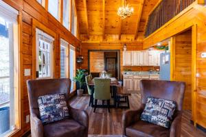 a living room with two chairs and a table at Mountain Majesty By Ghosal Luxury Lodging in Gatlinburg