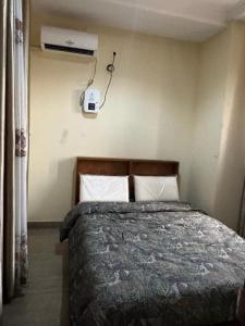 a bedroom with a bed with a air conditioner on the wall at Cozy home with a generator and Wi-Fi in Kinshasa