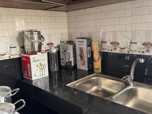 a kitchen counter with a stainless steel sink and a counter top at Cozy home with a generator and Wi-Fi in Kinshasa