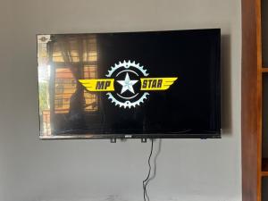 a television with a mr stir sign on the wall at Cozy home with a generator and Wi-Fi in Kinshasa