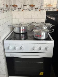 two pots and pans on a stove in a kitchen at Cozy home with a generator and Wi-Fi in Kinshasa