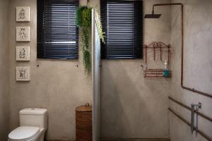 a bathroom with a toilet and a window with blinds at Gadute Haven - Luxury Apartment in Pretoria +16 photos