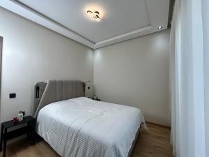 a bedroom with a bed and a light on the ceiling at Nakhla in Dar Bouazza