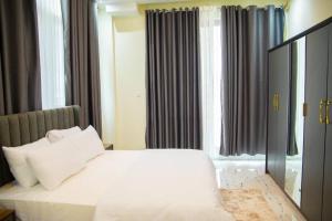 a bedroom with a bed with white sheets and pillows at Star home Tower in Mogadishu