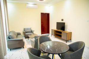 a living room with chairs and a tv and a table at Star home Tower in Mogadishu