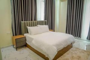 a bedroom with a white bed and a night stand at Star home Tower in Mogadishu