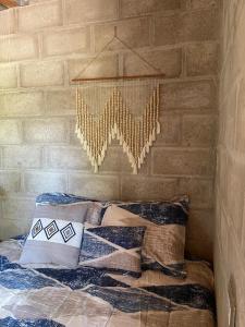 a bedroom with a bed with pillows and a wall at Quinta Las Hortensias in Monte San Juan +6 photos