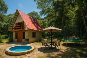 a house with a pool and a table and chairs and an umbrella at Quinta Las Hortensias in Monte San Juan
