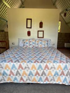 a bedroom with a bed with a colorful quilt at Quinta Las Hortensias in Monte San Juan