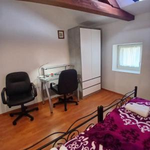 a bedroom with a desk and two chairs and a bed at Original Mediterranean house in Vodnjan