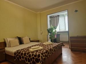 a bedroom with a bed with two towels on it at Three Rooms Comfort in Chişinău