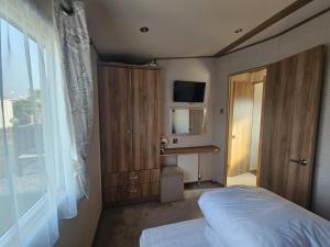a bedroom with a bed and a tv and a window at A21 Unity Beach, Brean in Brean +6 photos