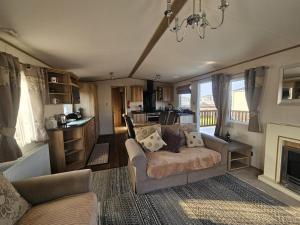 a living room with a couch and a kitchen at A21 Unity Beach, Brean in Brean