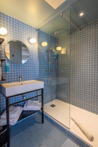 a blue tiled bathroom with a shower and a sink at Urban Hotel & Spa Aix-les-Bains - BW Signature Collection in Aix-les-Bains