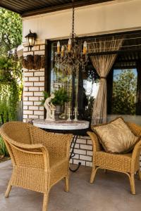 a patio with a table and chairs and a chandelier at Gadute Haven - Luxury Apartment in Pretoria