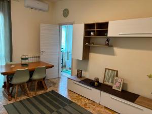 a living room with a table and a dining room at Nicole's House in Asti