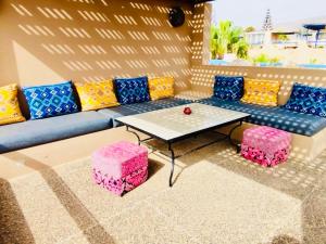 a living room with a couch and a table and stools at DreamCatcher Homes in Mirleft