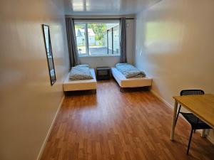 a room with two beds and a window at Brufjell Hostel & Parking in Flekkefjord