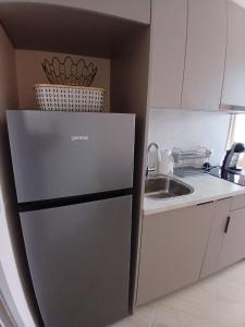 a small kitchen with a refrigerator and a sink at Sea&Sunset Studio in Sozopol