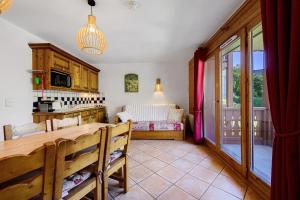 a kitchen and living room with a table and chairs at Les Ancolies Benelli in Les Menuires
