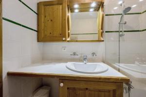 a bathroom with a sink and a mirror at Les Ancolies Benelli in Les Menuires +15 photos