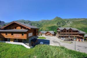 a group of buildings with mountains in the background at Les Ancolies Benelli in Les Menuires