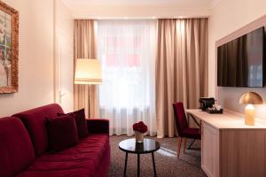 a living room with a red couch and a table at Hotel St.Gotthard in Zurich