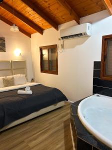 a bedroom with a bed and a bath tub at Orr Halevana in Bruchim Qela' Alon