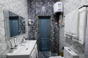 a bathroom with a blue door and a sink at Istanbul Palace Hotel in Urganch