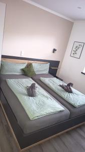 two beds in a room with two stuffed animals on them at Barrierefreie Ferienwohnung Morgentau in Pewsum, 1 - 4 Personen in Krummhörn