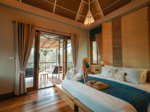a woman sitting on a large bed in a bedroom at The Spa Koh Chang Resort in Ko Chang +107 photos