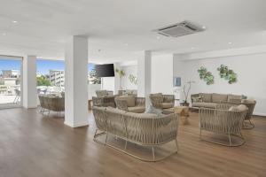 a living room with couches and chairs and a table at Hotel Palia Las Palomas in Torremolinos