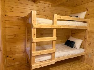 two bunk beds in a wooden cabin at Tiny Cabin #1 by Windham NY Escape 'Catskill Gem' in Hensonville