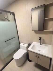 a bathroom with a toilet and a sink and a shower at #1 Diamond Hotel and Residences in Georgetown