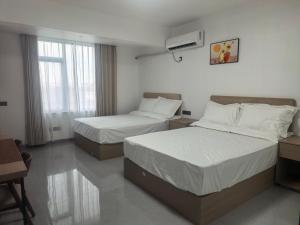 a hotel room with two beds and a window at #1 Diamond Hotel and Residences in Georgetown