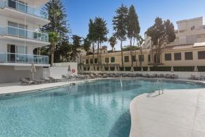 a swimming pool in front of a building at Hotel Palia Las Palomas in Torremolinos