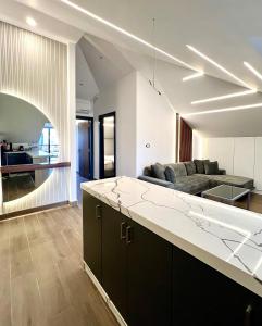 eine offene Küche und ein Wohnzimmer mit Sofa in der Unterkunft Elite Residence - Koura , Near Tripoli in An Nakhlah