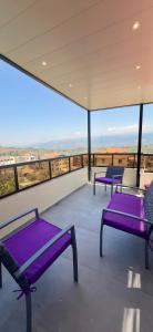 drei lila Bänke auf einem Balkon mit Aussicht in der Unterkunft Elite Residence - Koura , Near Tripoli in An Nakhlah