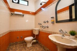a bathroom with a toilet and a sink at Hotel Arina in Chandīgarh +5 photos