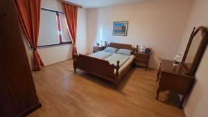 a bedroom with a bed and a table and a window at Apartmani Rama - terra nostra in Prozor