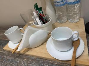 a wooden cutting board with two cups and saucers at Sherpa space in Almaty