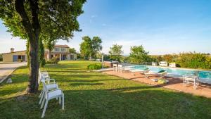 a yard with chairs and a swimming pool at Villa Elettra 12&2 by Marche Holiday Villas in San Costanzo