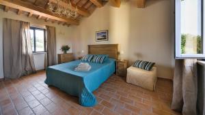 a bedroom with a blue bed and a chair at Villa Elettra 12&2 by Marche Holiday Villas in San Costanzo +61 photos