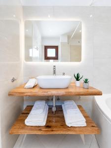 a bathroom with a sink and a mirror at Patmos Sunshine Houses - Quiet Stay, 5-min Walk to Skala Square in Patmos +46 photos